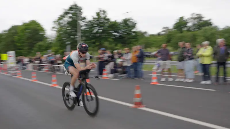 Radfahrer auf der abgesperrten Strecke, Zuschauer am Rand
